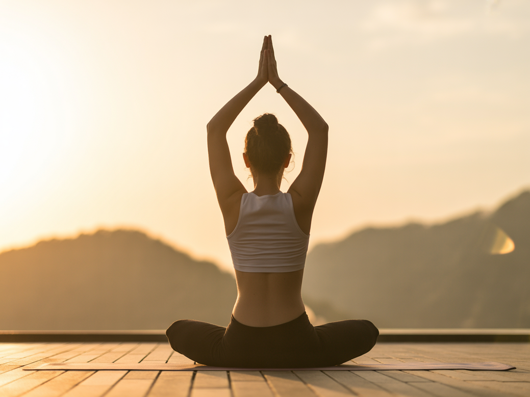 Mulher praticando yoga em um ambiente tranquilo, representando o conceito de bem-estar integral para iniciantes.