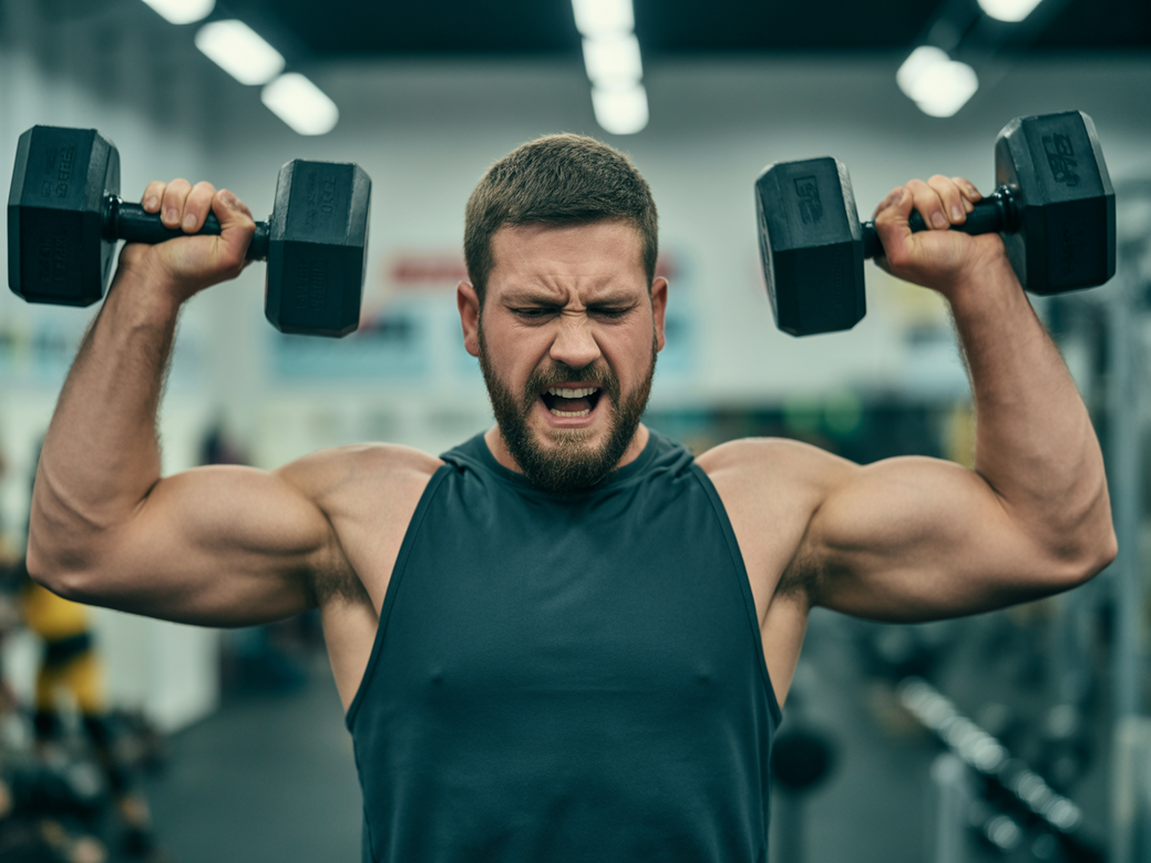 Homem realizando encolhimento de ombros na máquina específica para trapézio