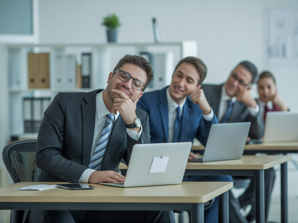 Funcionários engajados fazendo exercícios rápidos de alongamento em suas mesas de escritório, uma das dicas motivacionais para perder peso no trabalho.